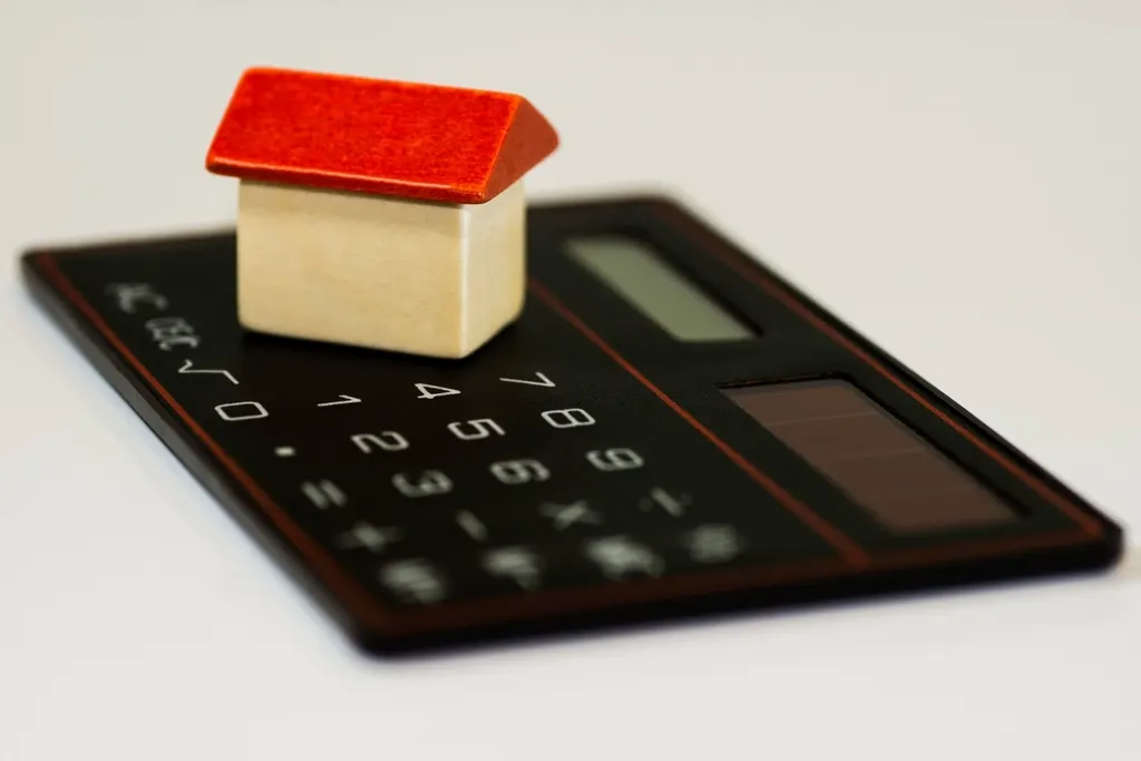 Calculadora junto a monedas y un cuaderno